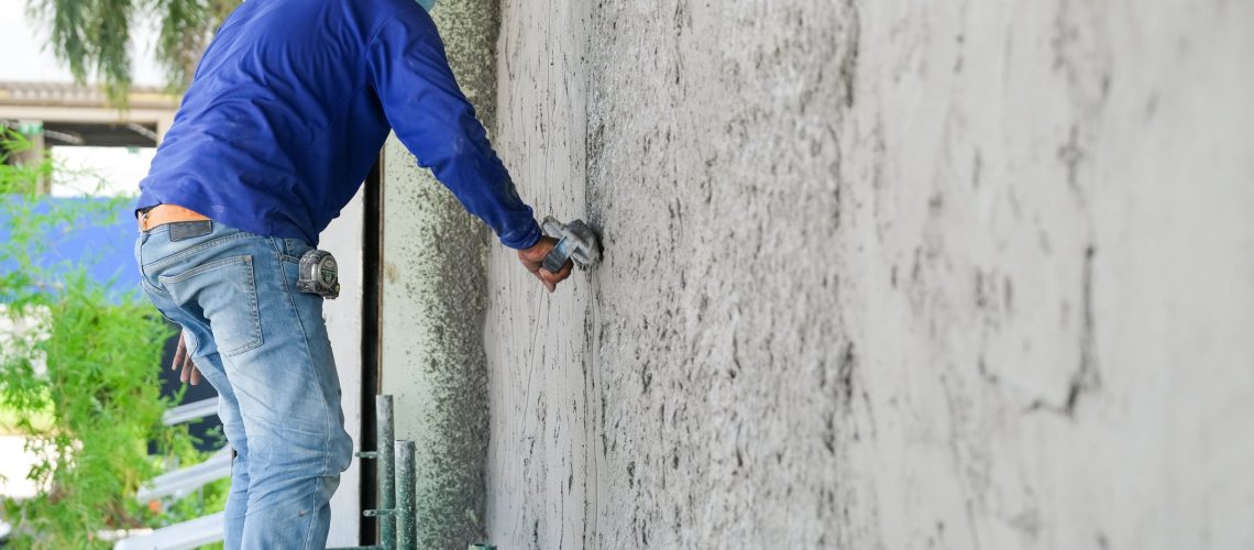 Plasterers using trowels mason for plastering and leveling mortar concrete on the brick wall at the construction under building